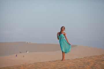Beautiful young woman meeting dawn in the desert. The start of a new day. Freshness of the morning....