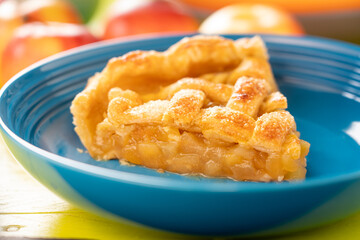 Apple pie portion of en served on a blue plate.