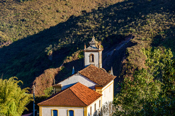 Fototapeta na wymiar Historic baroque church in Ouro Preto city with hill in the background during the late afternoon
