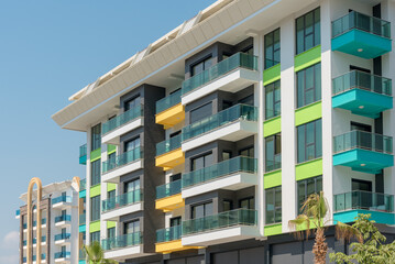 Modern freshly built apartment buildings on a sunny day with blue sky.