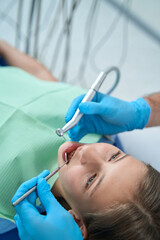 Fototapeta premium Experienced doctor treating caries in young patient