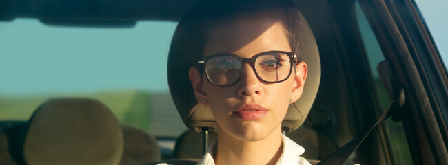 Young woman driving car on a sunny summer day