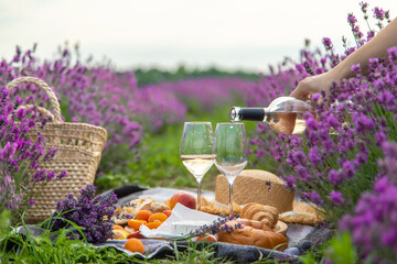 A bottle of wine on a background of a lavender field. Glasses with wine, fruits.