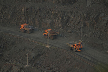 Transportation of minerals by dump trucks in the quarry. Technologies of open pit mining of...