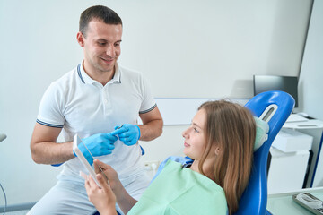 Teenage girl sitting in dentist office at initial dental consultation