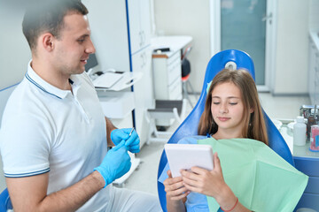 Teenage patient sitting in dentist office at initial consultation