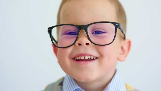 portrait happy caucasian baby boy child eyeglasses, child 4 years laughing smile, looking to camera. schoolboy pre elementary kindergarten age, wide smiling showing white teeth. back to school concept