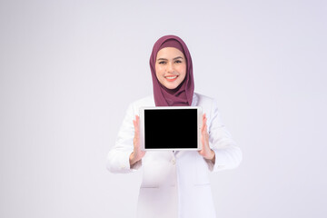 Beautiful muslim business woman wearing white suit with hijab holding tablet in studio.