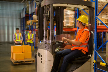 Forklift loader working between shelves full of packed boxes in warehouse, machinery and Logistics concept.