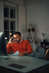 The tired man staring at his computer, feeling tired, working overtime.