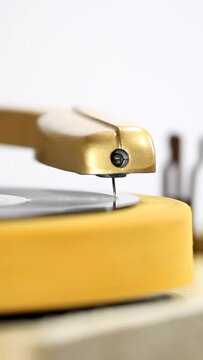 Vintage turntable needle on spinning vinyl record macro vertical video.