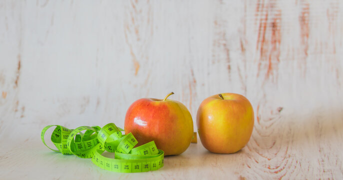 Apples And Measuring Tape On A Wooden Background, Loosing Weight, Diet And Healthy Eating Concept