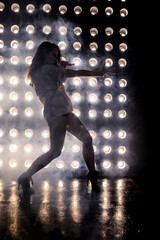 Sexy girl dance on front of spot light wall with smoke