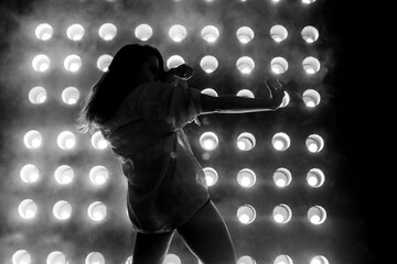 Sexy girl dance on front of spot light wall with smoke