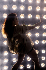 Sexy girl dance on front of spot light wall with smoke