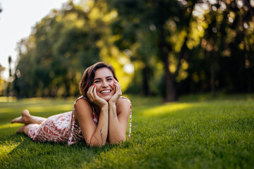 Portrait of a cute, smiling girl, laying on her stomach and posing for the photo.