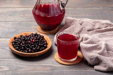 blackcurrant compote in a glass  and pitcher and berries on a table