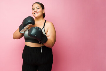 Portrait of a happy plus size woman practicing a boxing workout