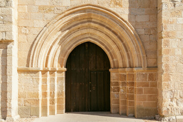 Fototapeta na wymiar Simple entrance door to a Romanesque church. Selective focus. Copy space.