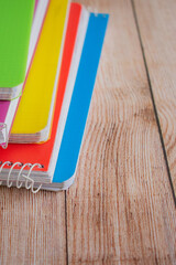 group of colored notebooks on a wooden table
