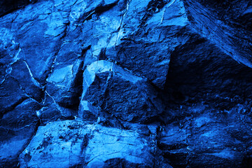 Rock texture. Navy blue color. Toned rough mountain surface with cracks. Close-up. Stone granite background for design. Crashed, crumbled, ruined, broken. Grunge background. Wallpaper.