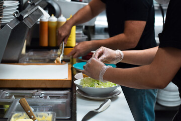 Kitchen employees working on a customer food order