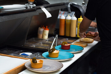 Restaurant kitchen employee working on preparing customer food order