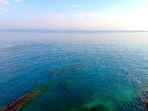 View from the sea at morning. Calm sea water and clear blue sky.