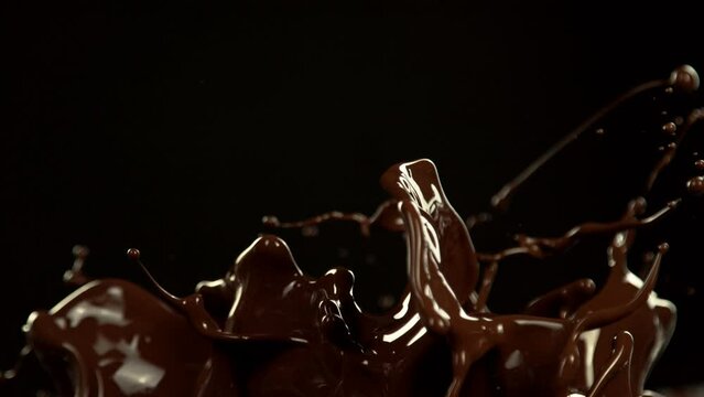Super Slow Motion of Melted Chocolate Splashing in Waves shapes. Isolated on Black Background. Filmed on High Speed Cinema Camera in 4k, 1000fps.