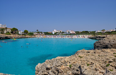 Menorca, Spain: Cala en Bosch beach minorca . Cami de cavalls. Beautiful minorca beach with small hotel in the background. white sand and turquoise water