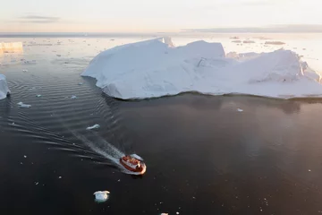 Fotobehang Small ship cruising among ice bergs during beautiful summer day. Disko Bay, Greenland. Climate change and global warming. © Michal