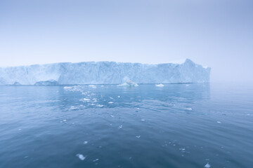 Fototapeta na wymiar Climate change and global warming. Icebergs from a melting glacier in Ilulissat Glacier, Greenland. The icy landscape of the Arctic nature in the UNESCO world heritage site.