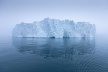 Fototapeta na wymiar Climate change and global warming. Icebergs from a melting glacier in Ilulissat Glacier, Greenland. The icy landscape of the Arctic nature in the UNESCO world heritage site.