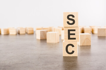 SEC text as a symbol on cube wooden blocks. many wooden blocks in the background.