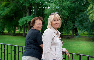 Fototapeta premium Friends of 50-60 years old spend a day off in the park. Retirement travel time