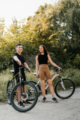 Obraz premium Cheerful young couple with bikes outdoors.