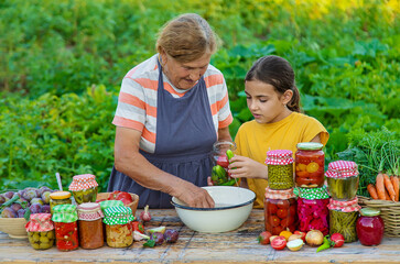 Women with jar preserved vegetables for the winter mother and daughter. Selective focus.