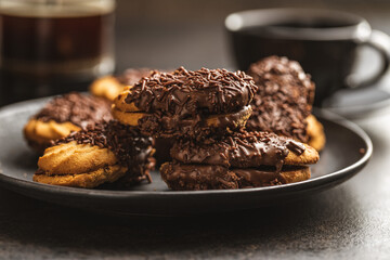 Petit fours with chocolate sprinkles. Mini chocolate dessert on plate.