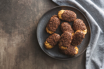 Petit fours with chocolate sprinkles. Mini chocolate dessert on plate.