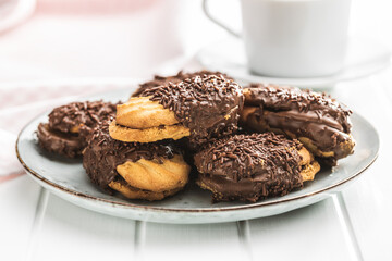 Petit fours with chocolate sprinkles. Mini chocolate dessert on plate.
