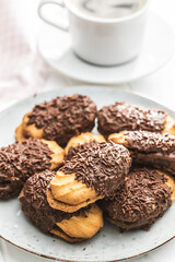 Petit fours with chocolate sprinkles. Mini chocolate dessert on plate.