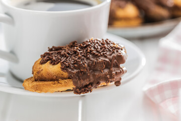 Petit fours with chocolate sprinkles. Mini chocolate dessert and coffee cup.