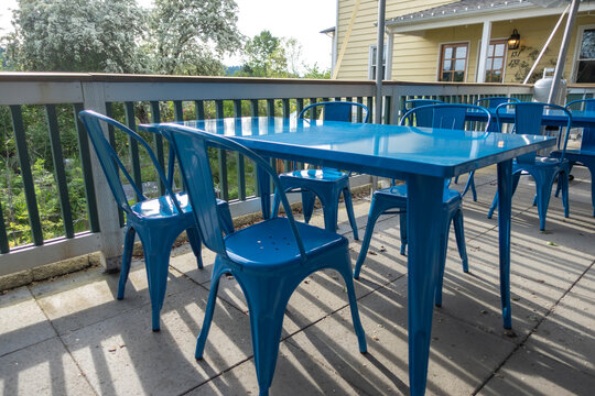 Colorful view of bright blue chairs gathered around a blue table on an outdoor patio at a restaurant