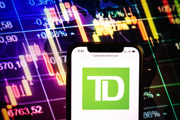 Fototapeta premium KONSKIE, POLAND - August 09, 2022: Smartphone displaying logo of Toronto Dominion Bank company on stock exchange chart background