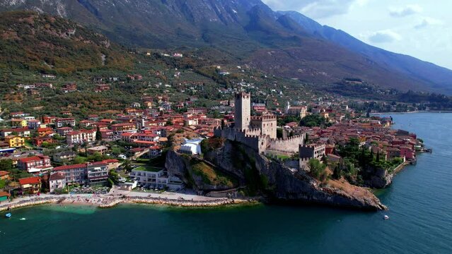 Amazing italian lake scenery - beautiful Lago di Garda. Aerial view of Malcesine castle ,village and beach. drone 4k nd footage