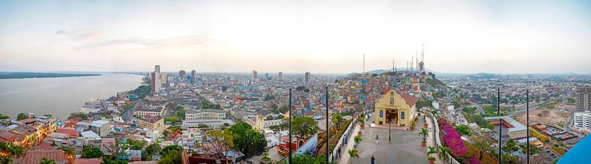 Obraz premium Panoramic photo of the view of Guayaquil from the top of the lighthouse on the Cerro Santa Ana (Saint Ana hill), a moment before sunset after a warm sunny summer day. Ecuador.