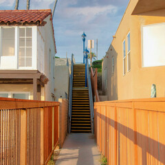 Square Puffy clouds at sunset Fenced pathway leading to the stairs at Oceanside, California