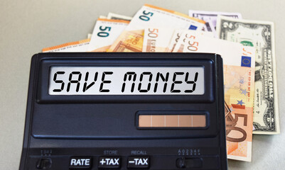 SAVE MONEY text written on a calculator next to the background of euro banknotes. Finance or business concept.