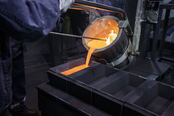 Pouring hot liquid silver into molds.