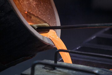 Pouring hot liquid silver into molds.